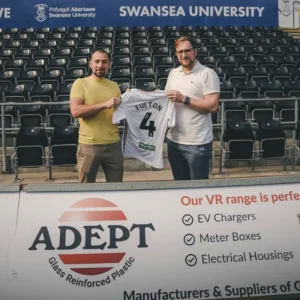 Director Dan Phillips and Sales & Design Manager Lukasz Rzepecki hold Jay Fultons signed shirt,